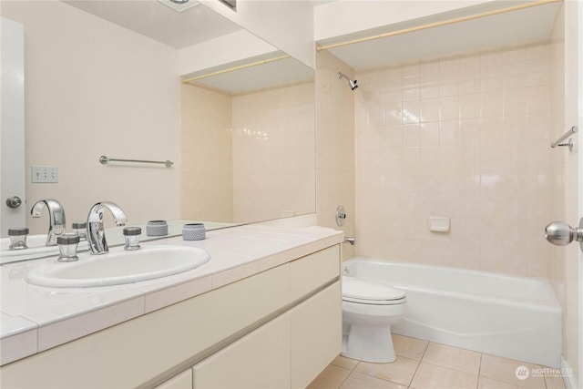 full bathroom with tile patterned flooring, vanity, tiled shower / bath combo, and toilet