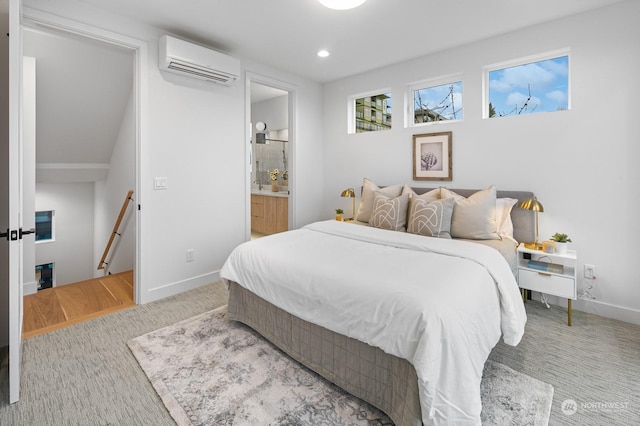 bedroom featuring connected bathroom, carpet floors, and an AC wall unit