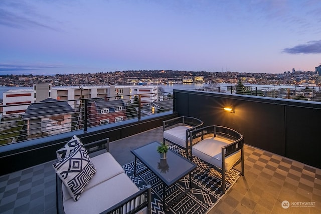 patio terrace at dusk with a balcony and an outdoor living space