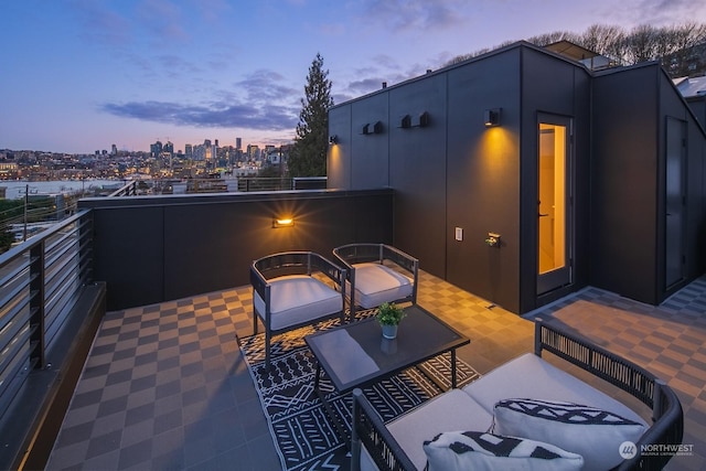 patio terrace at dusk featuring a balcony