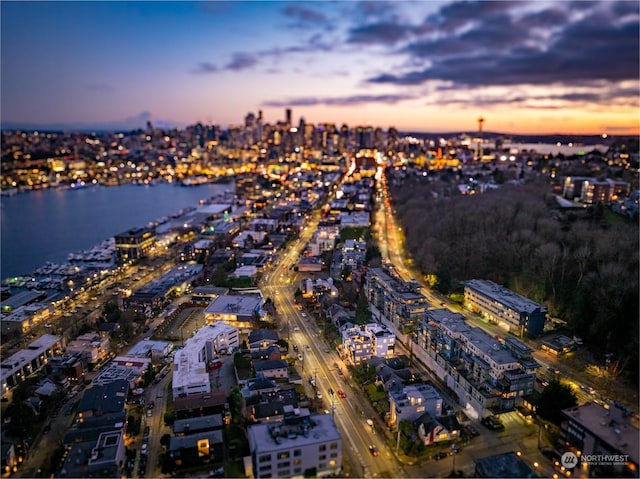 aerial view at dusk featuring a water view