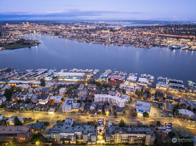 aerial view at dusk featuring a water view