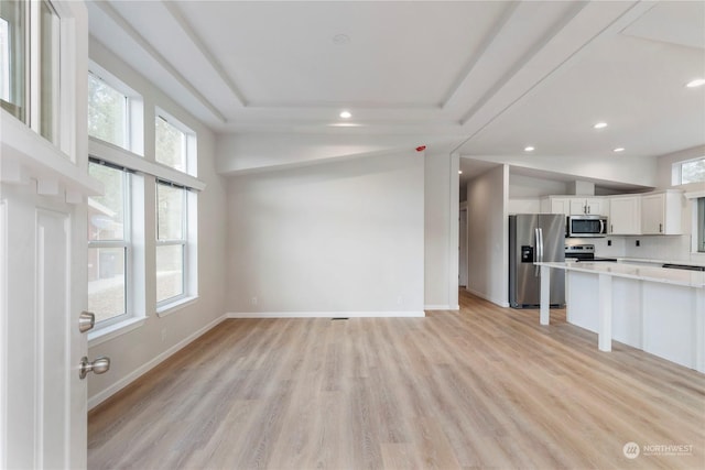 unfurnished living room featuring light wood-type flooring and vaulted ceiling