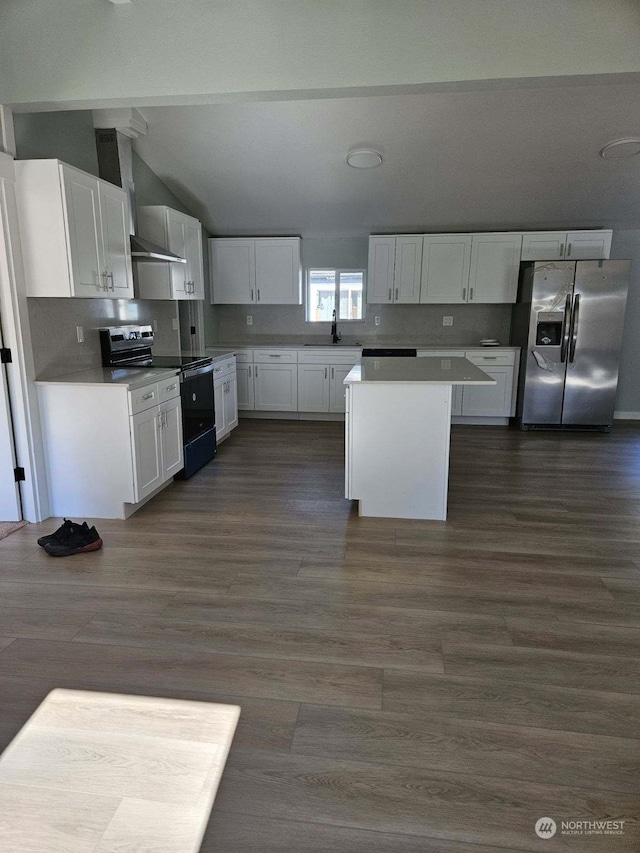 kitchen with stainless steel fridge, sink, white cabinetry, electric stove, and a kitchen island