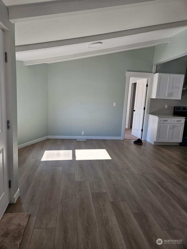 unfurnished living room with dark hardwood / wood-style floors and beamed ceiling