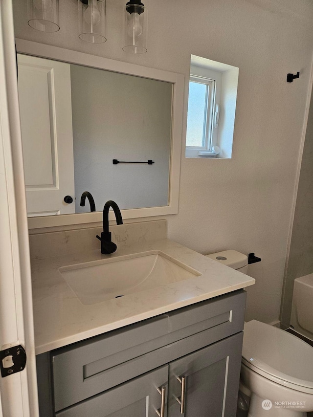 bathroom featuring toilet and vanity