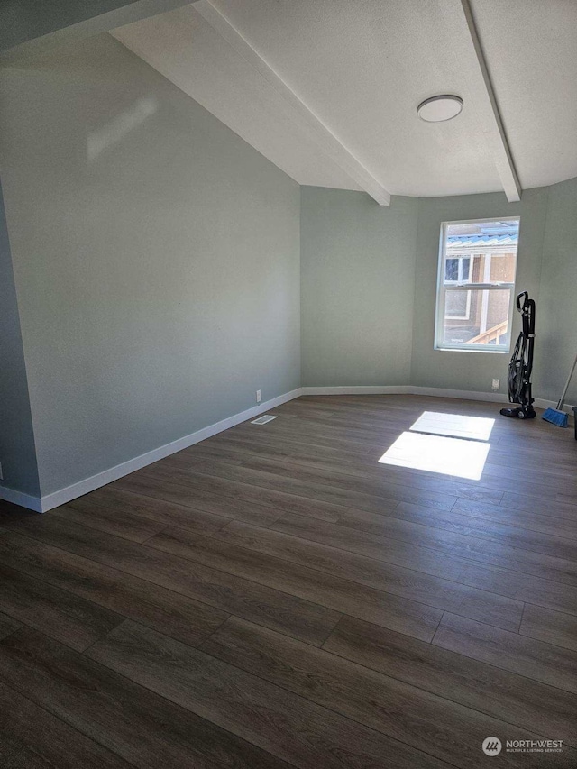 additional living space featuring dark hardwood / wood-style flooring and beam ceiling