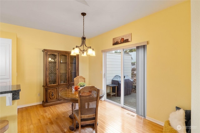 dining space featuring an inviting chandelier and light hardwood / wood-style floors