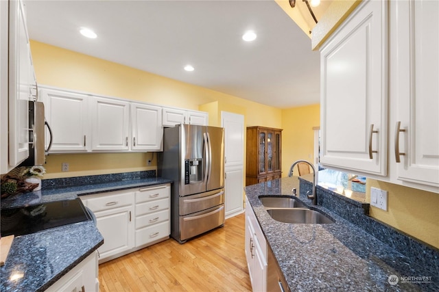 kitchen featuring sink, dark stone counters, white cabinets, and appliances with stainless steel finishes