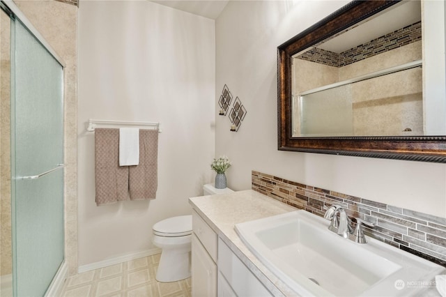 bathroom featuring toilet, tasteful backsplash, an enclosed shower, and vanity