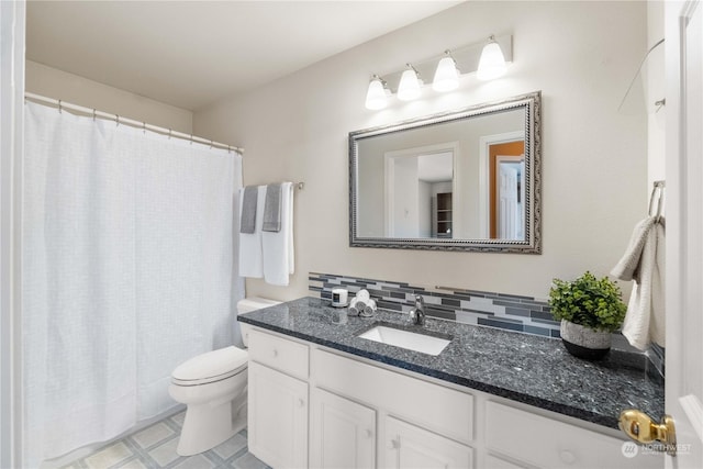 bathroom with vanity, toilet, and tasteful backsplash