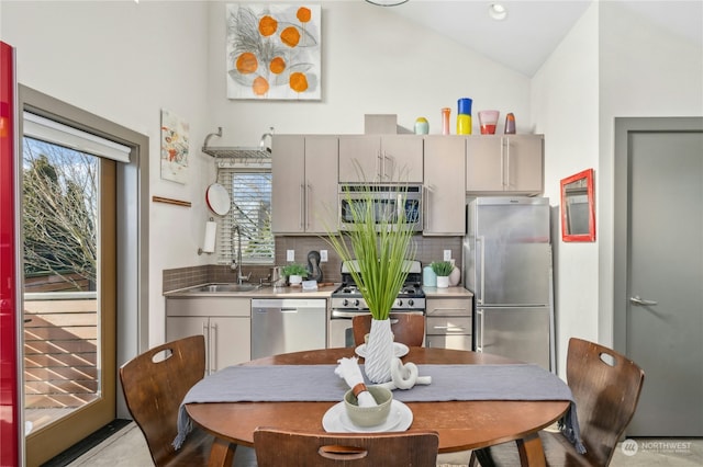 kitchen with gray cabinets, appliances with stainless steel finishes, sink, backsplash, and stainless steel counters