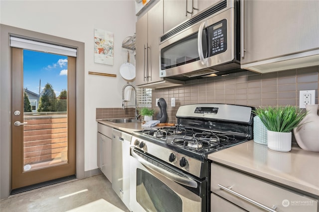 kitchen with appliances with stainless steel finishes, sink, and decorative backsplash