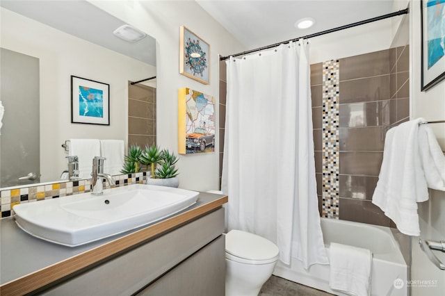 full bathroom featuring vanity, shower / bath combo with shower curtain, and toilet