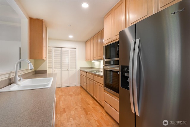 22635 SE 44th Pl Unit 1631, Issaquah, WA 98029 - kitchen featuring black appliances, a sink, light brown cabinets, light wood-style flooring, and recessed lighting