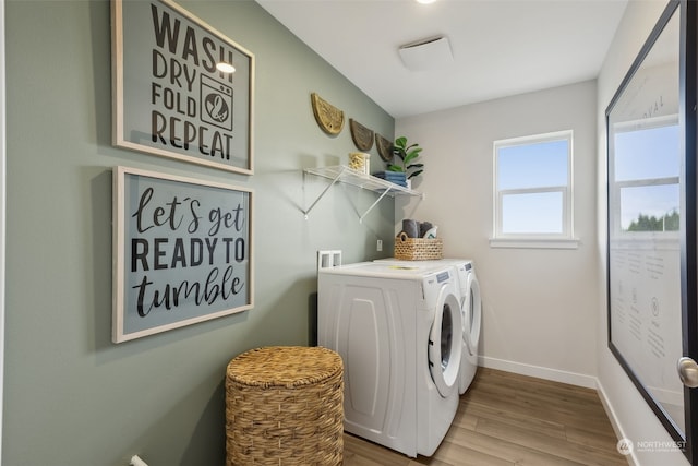 clothes washing area with hardwood / wood-style flooring and washing machine and clothes dryer