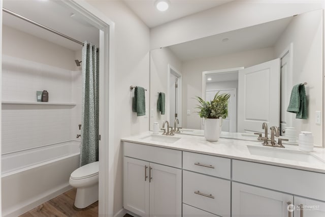 full bathroom featuring vanity, hardwood / wood-style floors, shower / tub combo, and toilet