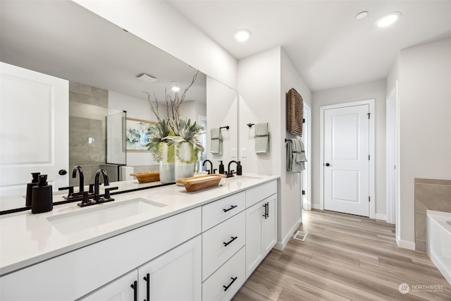 bathroom featuring vanity, hardwood / wood-style floors, and a bathing tub