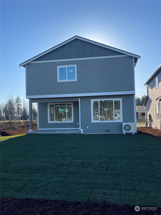 rear view of house featuring ac unit and a lawn