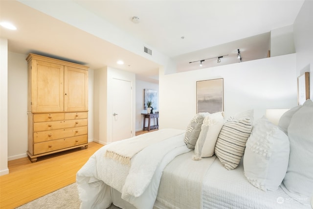 bedroom featuring light wood-type flooring and rail lighting