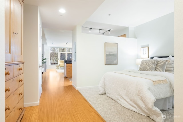 bedroom featuring light hardwood / wood-style floors and rail lighting