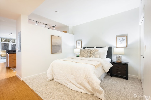 bedroom with wood-type flooring and track lighting