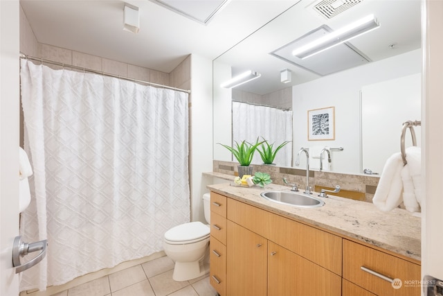 bathroom with toilet, vanity, and tile patterned flooring