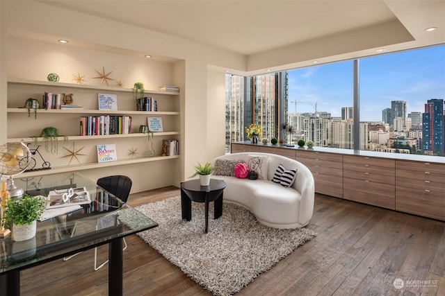 sitting room featuring hardwood / wood-style floors and built in shelves