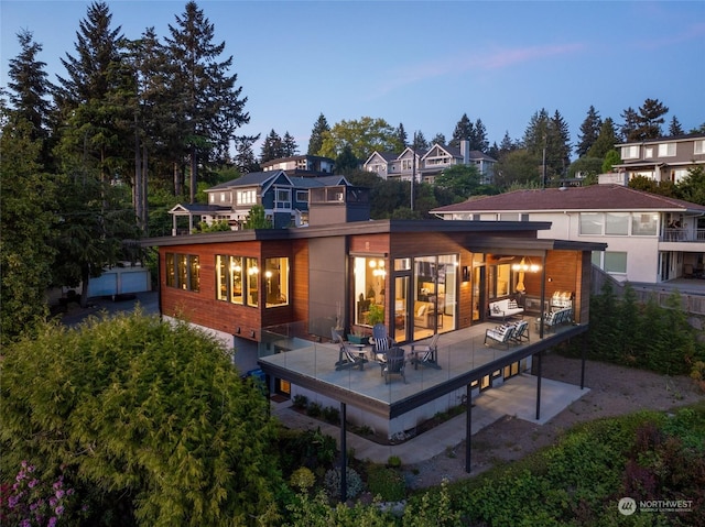 back house at dusk featuring a patio area