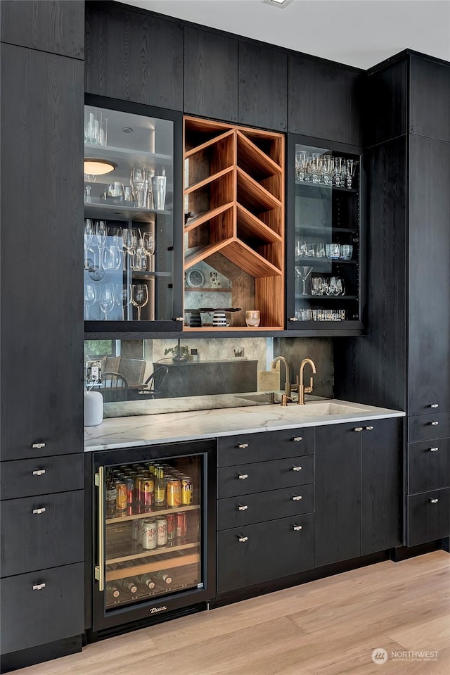 bar featuring beverage cooler and light wood-type flooring