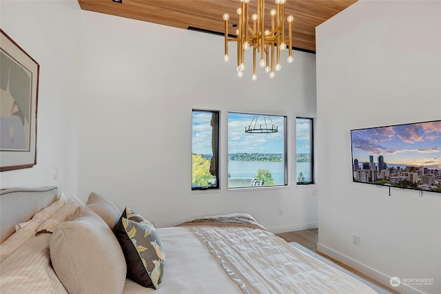 bedroom with wood ceiling, an inviting chandelier, and hardwood / wood-style floors