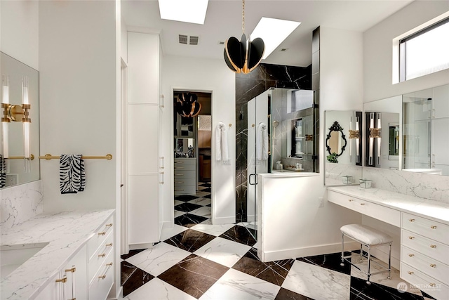 bathroom with an enclosed shower, vanity, and a skylight