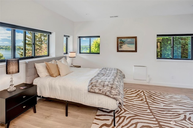 bedroom with a water view and light wood-type flooring