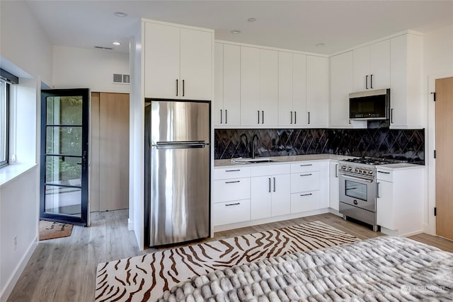 kitchen with sink, white cabinets, and stainless steel appliances