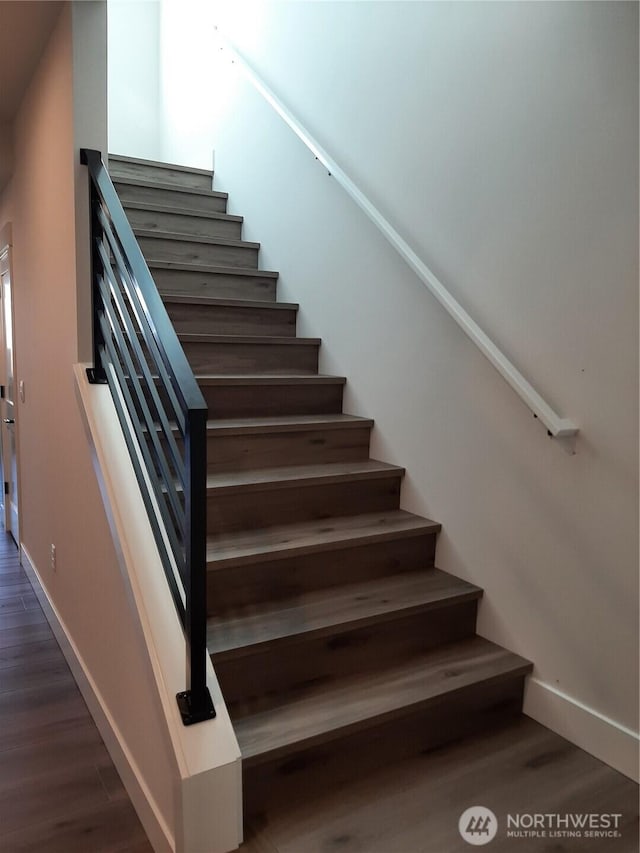 stairway with baseboards and wood finished floors