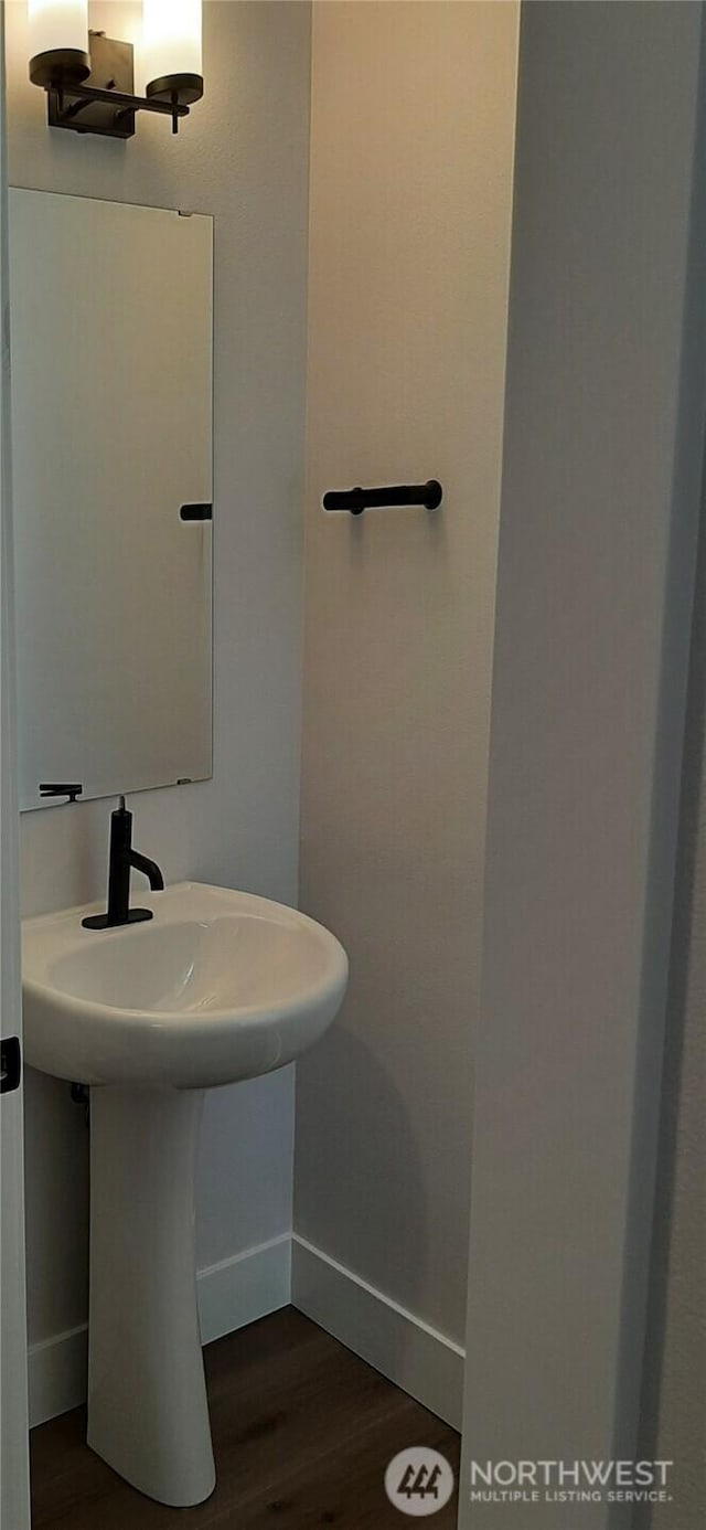 bathroom featuring a sink, baseboards, and wood finished floors