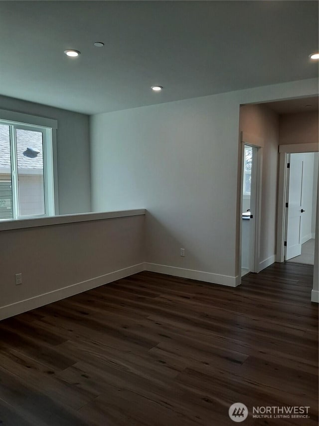 spare room with recessed lighting, dark wood finished floors, and baseboards