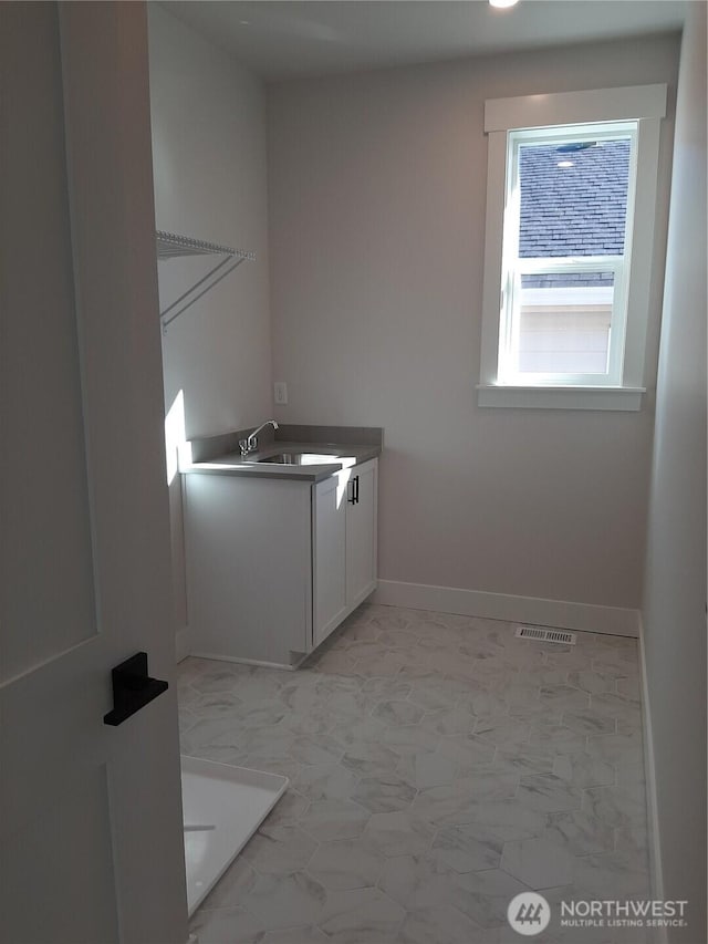 laundry room with marble finish floor, baseboards, visible vents, and a sink