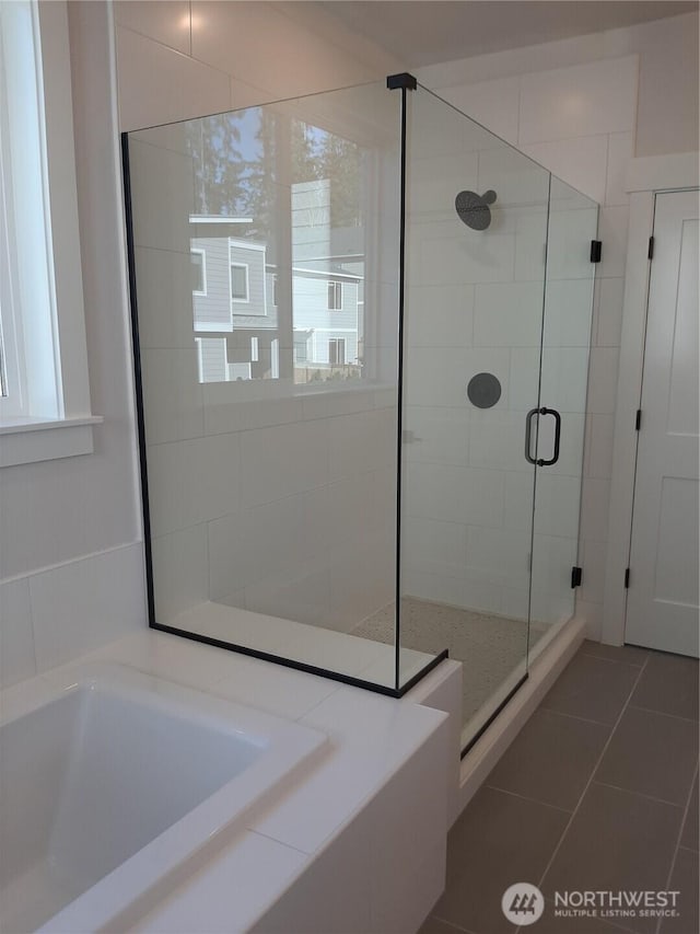 bathroom with a stall shower, a sink, a bath, and tile patterned floors