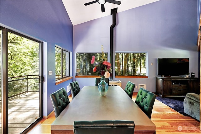 dining area featuring ceiling fan, vaulted ceiling, and light hardwood / wood-style flooring