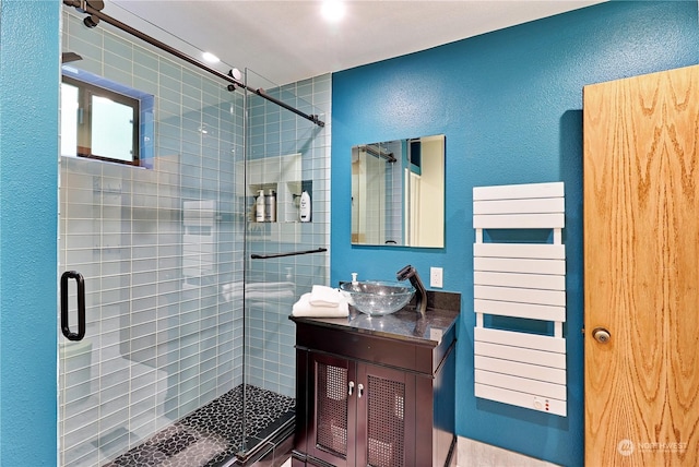 bathroom with vanity, radiator, and an enclosed shower