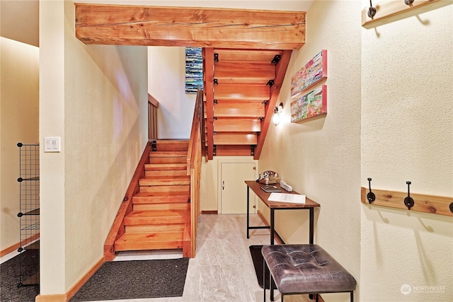 staircase with beamed ceiling