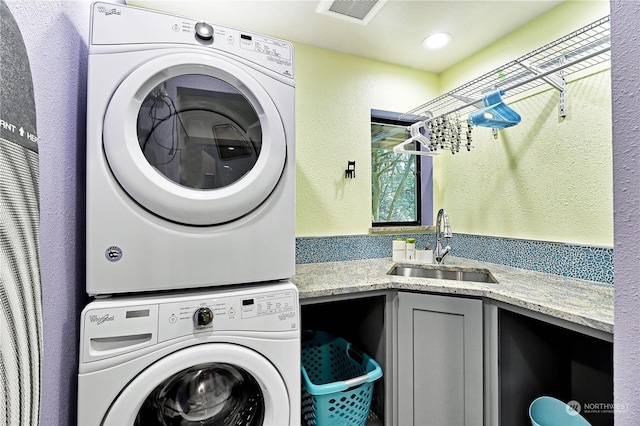 laundry room featuring stacked washer and dryer and sink