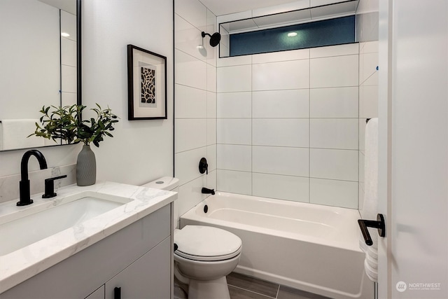 full bathroom with tiled shower / bath, vanity, and toilet