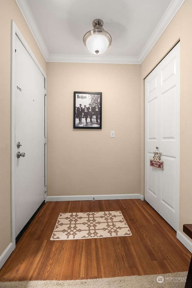 foyer entrance with ornamental molding and dark hardwood / wood-style flooring