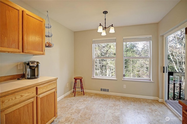 kitchen featuring pendant lighting and a notable chandelier