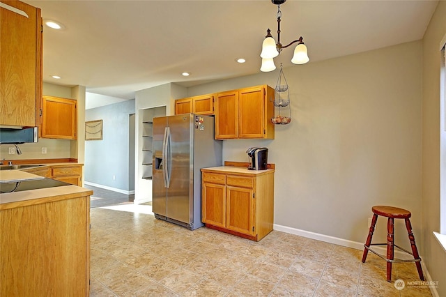 kitchen with sink, decorative light fixtures, and stainless steel fridge