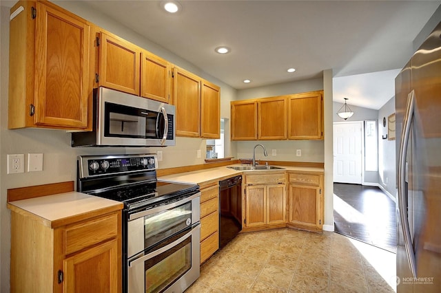 kitchen with stainless steel appliances, hanging light fixtures, sink, and lofted ceiling