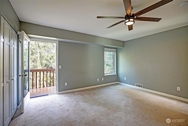 spare room featuring light carpet and ceiling fan