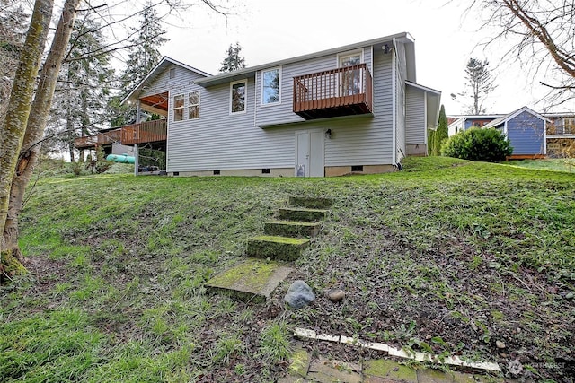 rear view of house featuring a yard and a balcony